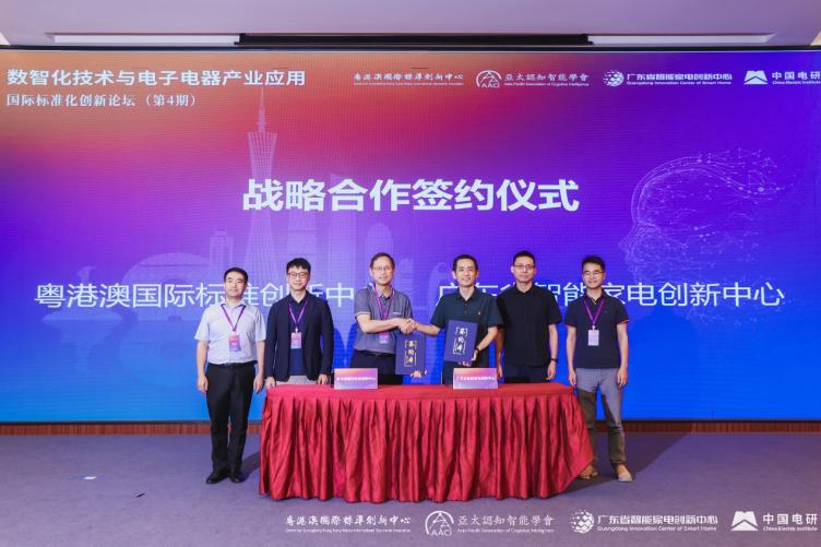 A group of people standing in front of a large screen

Description automatically generated